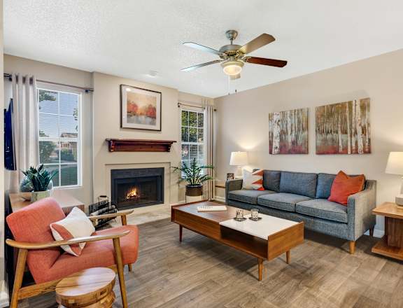 A living room with a fireplace, a couch, a chair, and a coffee table.
