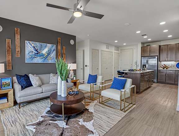 A living room with a grey couch, a coffee table, and a painting on the wall.