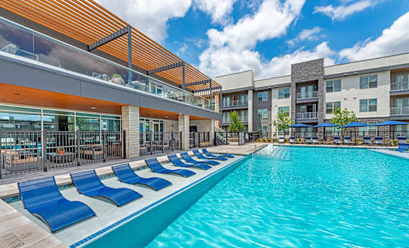 our apartments have a resort style pool with lounge chairs at Presidium Revelstoke, Texas