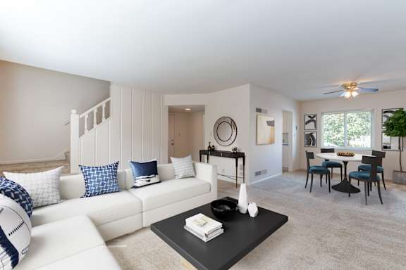 A living room with a white couch and a black coffee table.