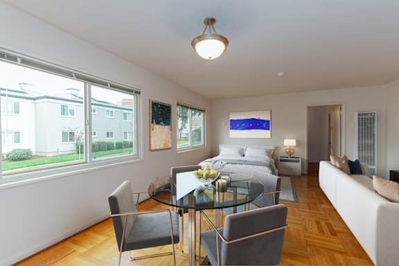 A modern living room with a glass dining table and chairs.