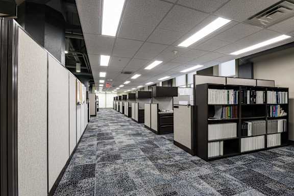 a library with rows of bookshelves and rows of cubicles at 100 South Apartments, Buffalo, 14202