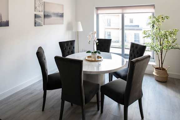 a dining room with a table and chairs and a window