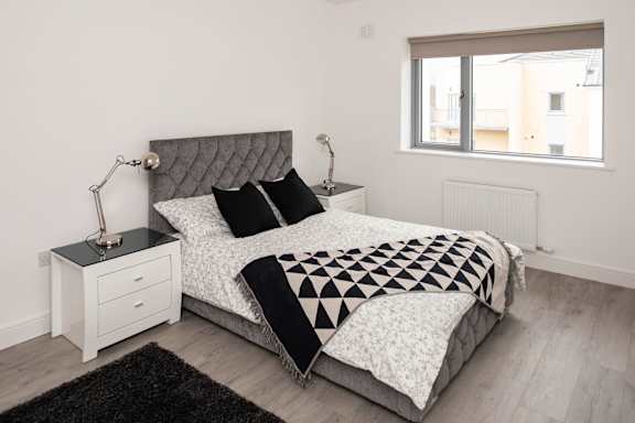 a bedroom with a bed and a black and white comforter