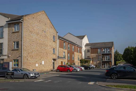 a city street with cars parked in front of brick apartment buildings