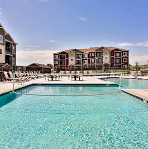 A swimming pool in front of apartment buildings.