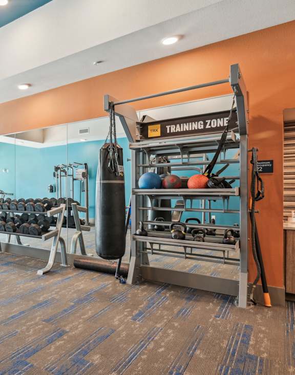 A gym with a variety of equipment including weights and a leg press machine.