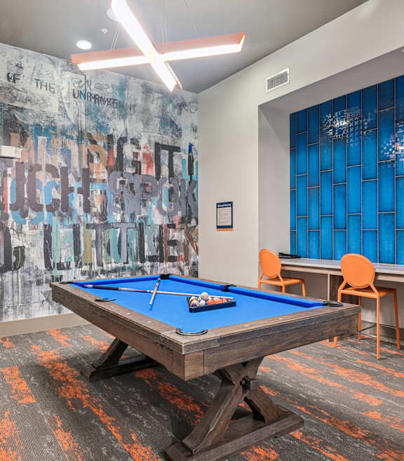 A pool table in a room with a graffiti wall.