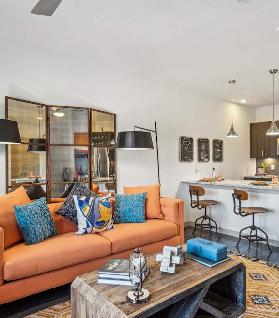 A modern living room with a kitchen in the background.