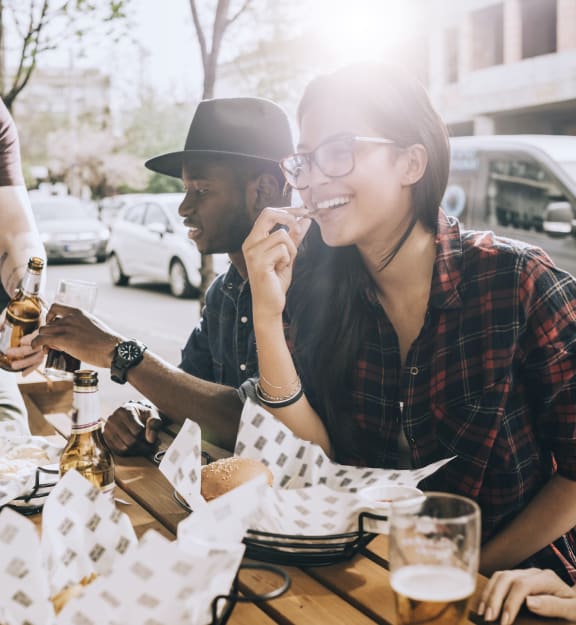 a group of people sitting at a table eating food and drinking beer at The Mason Mills Apartments, Georgia, 30033