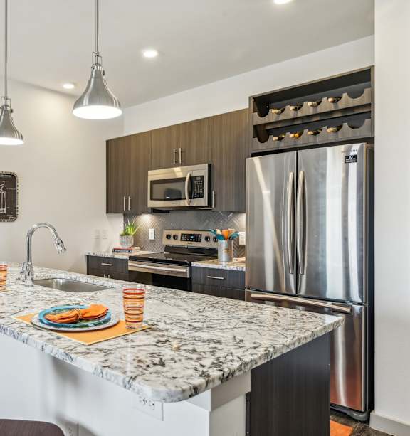 A kitchen with a marble countertop and a refrigerator.