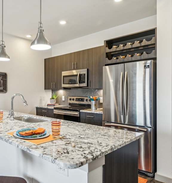 A kitchen with a marble countertop and a refrigerator.