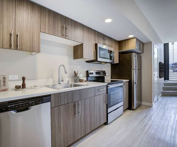 A modern kitchen with wooden cabinets and stainless steel appliances.