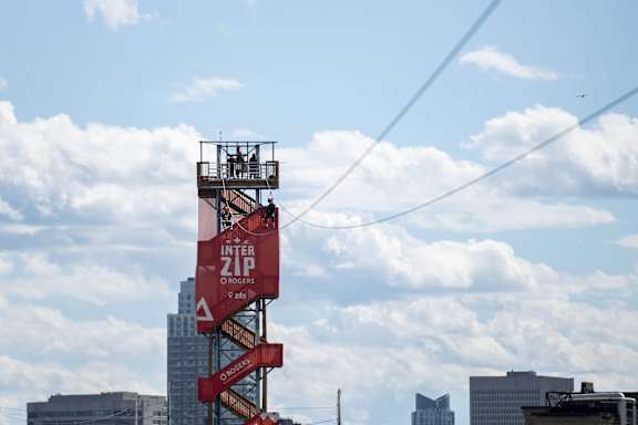 A red Inter Zip tower stands tall against a cloudy sky.