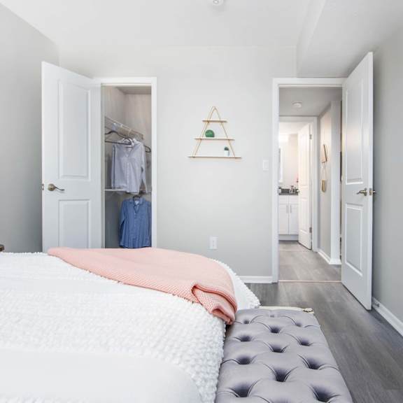 A bedroom with a large bed and a painting on the wall.