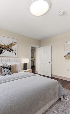 A bedroom with a large bed and a painting of a dragonfly on the wall at 206 Flats, Washington
