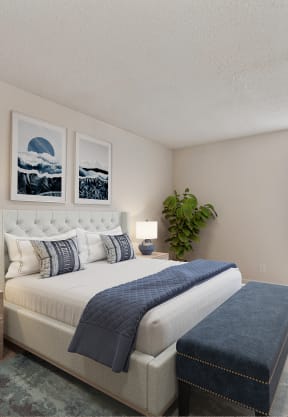 a blue and white bedroom with a bed and pillows at Vineyard Terrace Apartments, Napa, CA