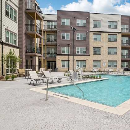 A large apartment complex with a pool in the courtyard.