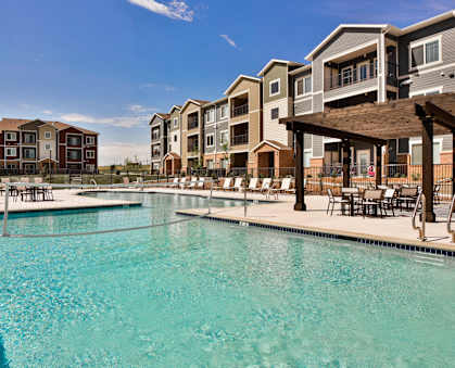 A swimming pool in front of apartment buildings.
