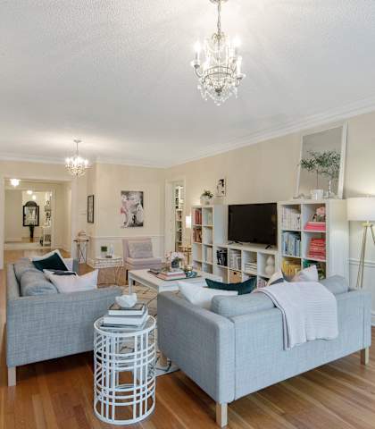 A living room with a grey couch and a white coffee table.