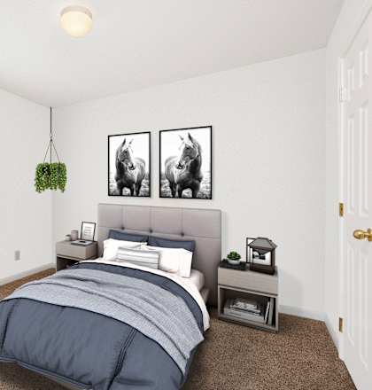 A bedroom with a bed, nightstand, and two framed pictures on the wall.