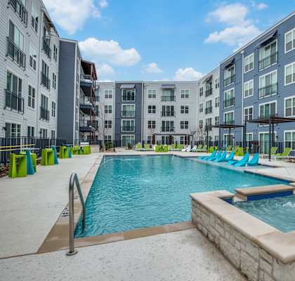 A swimming pool in front of apartment buildings.