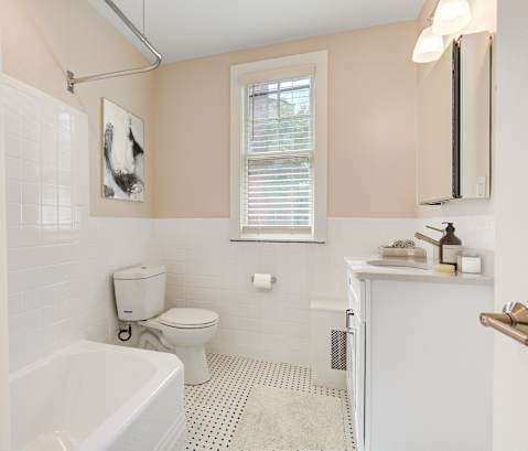a bathroom with a toilet and a tub and a sink