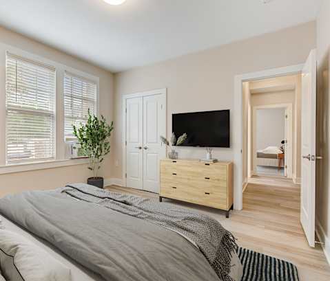 a bedroom with a bed and a tv on a dresser