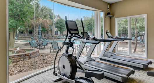 the retreat at thousand oaks apartments fitness center with gym equipment and large windows