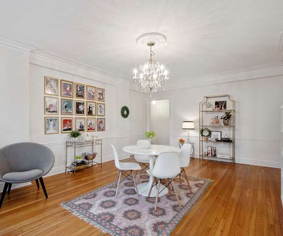 A white dining room with a round table and chairs.