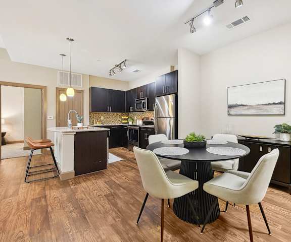 a dining room and kitchen with a table and chairs at Lakeline East Apartments, Cedar Park, TX