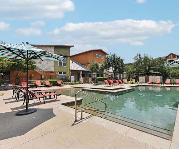 our resort style pool is filled with lounge chairs and umbrellas at Lakeline East Apartments, Texas, 78613