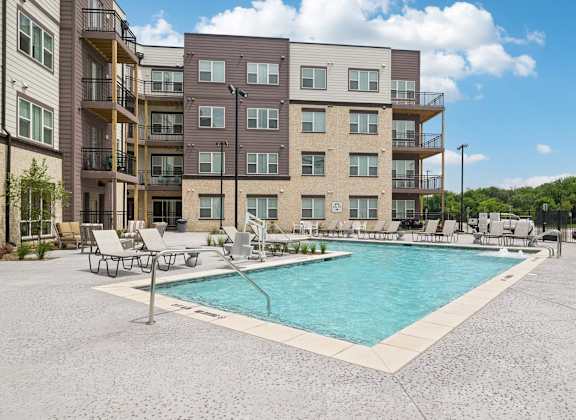 A large apartment complex with a pool in the courtyard.