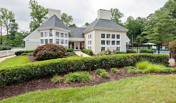 a house with a lawn and a hedge in front of it