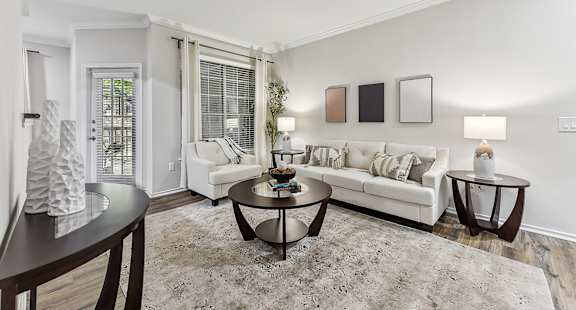 A living room with a white couch, a coffee table, and a rug. at Stone Oak @ Parmer, Austin, TX