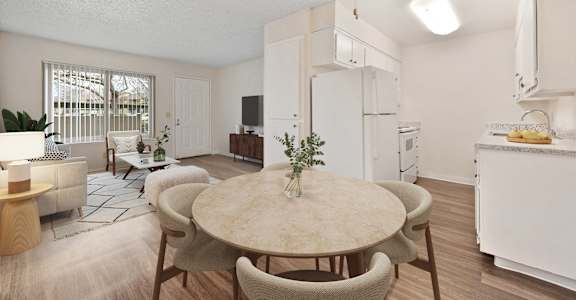 a living room and dining room with a table and chairs