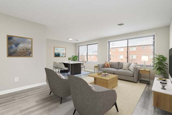 an open living room with a couch and chairs and a dining room table