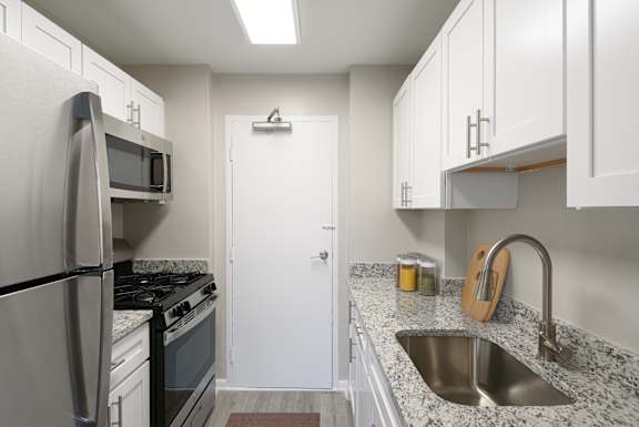 a kitchen with granite counter tops and white cabinets
