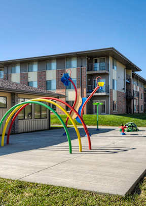 A playground with a colorful archway at Cedarbrooke Place , Norwalk, IA, Iowa , 50211