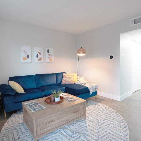 A blue couch sits in a living room with a coffee table in front of it.