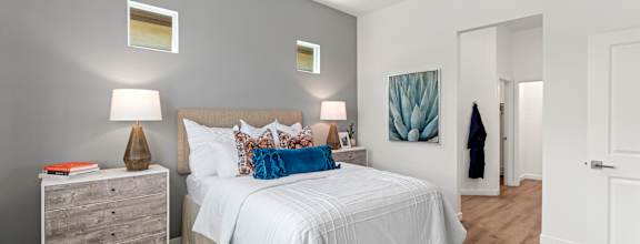 A bedroom with a white bed and a ceiling fan.