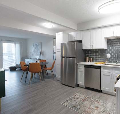 A modern kitchen with a dining table and chairs.