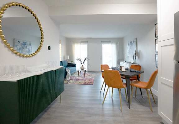 A dining room with a table and chairs.