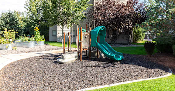 a playground in front of a house with a slide