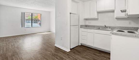 A kitchen with white cabinets and a refrigerator.
