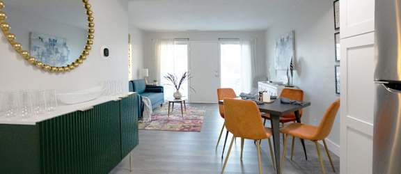 A dining room with a table and chairs.