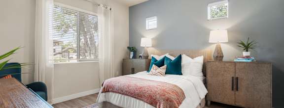 a walk in closet with white cabinets and a mirror