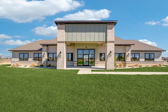 A modern house with a large front yard.