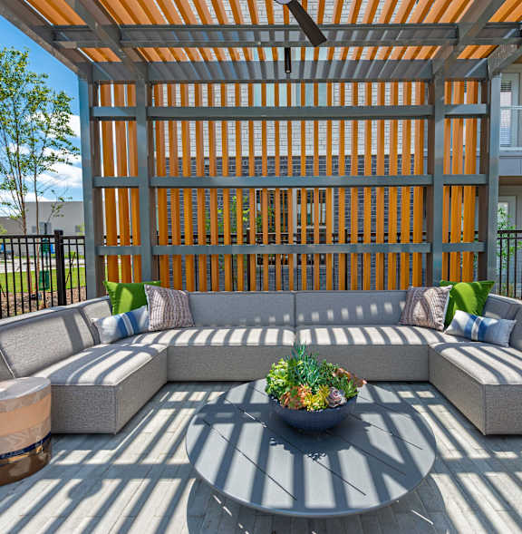 A patio with a table and chairs and a plant in a pot.