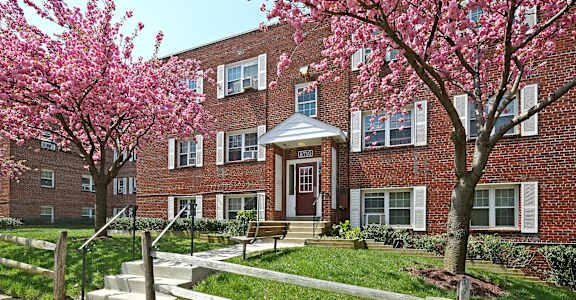 A red brick building with a tree in front of it.